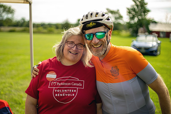 Male and female riders wearing helmets and smiling at camera